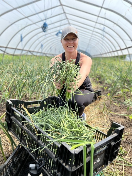 Erin on the farm picking garlic scapes